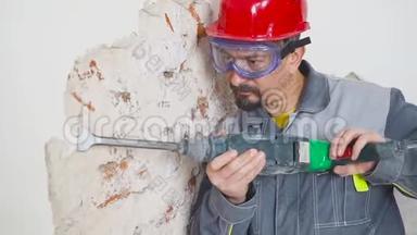 穿防护服的工人拆除石膏墙。 脏，<strong>辛苦</strong>.. 个人防护设备。 头盔、呼吸器